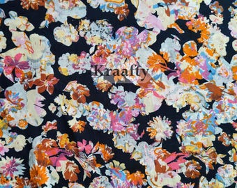 May include: A floral fabric featuring a dark background with a pattern of flowers in shades of orange, pink, yellow, and white. The word "Kraafty" is printed on the fabric.