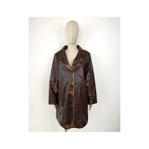 May include: A brown faux leather coat with a textured pattern. The coat has a collar, long sleeves, and a button closure.