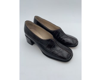 May include: A pair of brown crocodile-embossed leather heeled shoes with a square toe.