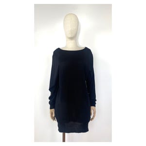 May include: A black long-sleeved sweater with a boat neck.