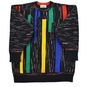 Könnte beinhalten: Schwarzer Pullover mit vertikalen Streifen in Rot, Gelb, Grün und Blau. Der Pullover hat einen Rundhalsausschnitt mit rotem Kragen und schwarzen Bündchen. Die Ärmel und der Körper haben ein strukturiertes Muster. Der Markenname "Carlo Colucci" ist sichtbar.