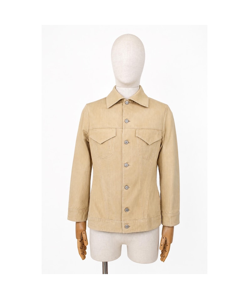 May include: A beige jacket with a traditional collar, two chest pockets, and button fastenings. The jacket is displayed on a mannequin. The jacket has long sleeves and a tailored fit, suitable for casual or semi-formal wear.