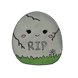 May include: A gray tombstone with a cute cartoon face, the words "RIP" and a small white flower. The tombstone is surrounded by green grass.
