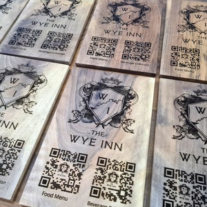 May include: Six wooden signs with a black and white crest featuring the letters "W I" and the text "The Wye Inn". Each sign has two QR codes, one labeled "Food Menu" and the other labeled "Beverage Collection".