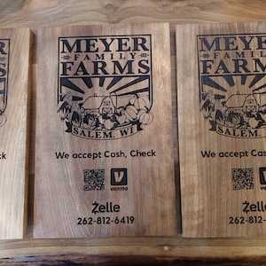 Könnte beinhalten: Drei Holzschilder mit dem Text "Meyer Family Farms" und einer Schwarzweißillustration einer Farmszene. Die Schilder enthalten auch den Text "Salem, WI" und Informationen über die Annahme von Barzahlungen, Schecks, Venmo und Zelle-Zahlungen.
