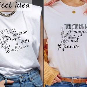 May include: Two white t-shirts with black text and floral designs. The first shirt says "You become what you believe" and the second shirt says "Turn your pain into purpose and power".