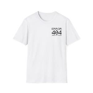 Può includere: Una t-shirt bianca a maniche corte con una grafica nera pixelata sulla parte superiore sinistra del petto. La grafica mostra il testo ERROR 404 seguito dal testo più piccolo sleep not found in uno stile di carattere per computer retrò.