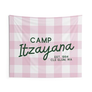 May include: A pink and white gingham tapestry with the text "CAMP Itzayana EST. 1994 CLE ELUM, WA" in green.