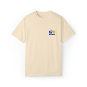 May include: A beige t-shirt with a blue graphic of a beer mug and the text "Viva Rat Riguez".