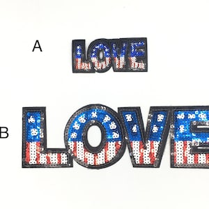 May include: Two iron-on patches with the word "LOVE" in large, bold letters. The letters are covered in sequins that are red, white, and blue, resembling the American flag. The smaller patch is labeled "A" and the larger patch is labeled "B".