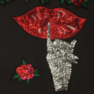 May include: A red sequined lips patch with a silver sequined finger pointing up, and a red sequined rose patch.