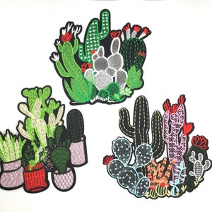 May include: Three embroidered iron-on patches featuring different arrangements of cacti and succulents. The first patch features a cluster of green cacti with red flowers. The second patch features a group of potted cacti and succulents in shades of green, white, and red. The third patch features a cluster of cacti in shades of green, pink, and red.