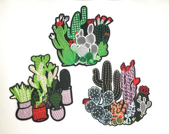 May include: Three embroidered iron-on patches featuring different arrangements of cacti and succulents. The first patch features a cluster of green cacti with red flowers. The second patch features a group of potted cacti and succulents in shades of green, white, and red. The third patch features a cluster of cacti in shades of green, pink, and red.