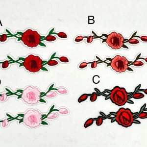 May include: Embroidered floral patches in red, pink, and coral. Each patch features a central flower with surrounding buds and green stems. The patches are outlined in white.