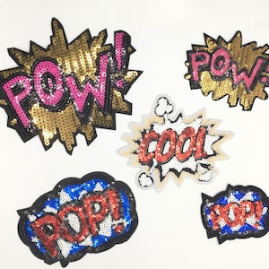 May include: Five colorful iron-on patches with different words in a comic book style. The patches are made of sequins and have a black outline. The words on the patches are "POW!" (twice), "COOL!" and "POP!"