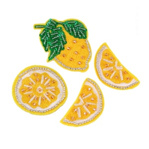 May include: Four embroidered lemon patches with yellow and green fabric and rhinestones. The patches include a whole lemon with a leaf, a lemon slice, and two half lemon slices.