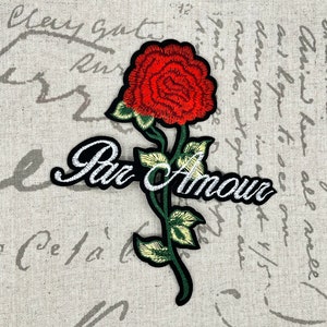 May include: Embroidered iron-on patch featuring a red rose with green leaves and a white cursive text that reads "Par Amour".
