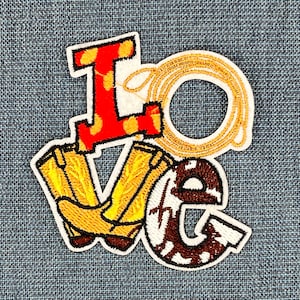 May include: Embroidered patch with the word "LOVE" in a western style. The letters are made of red, brown, and yellow fabric with a white outline. The "O" is a lasso and the "V" is a pair of cowboy boots.