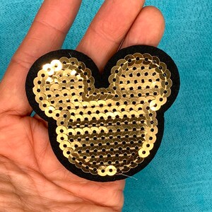 May include: Gold sequin Mickey Mouse head patch with black felt backing.
