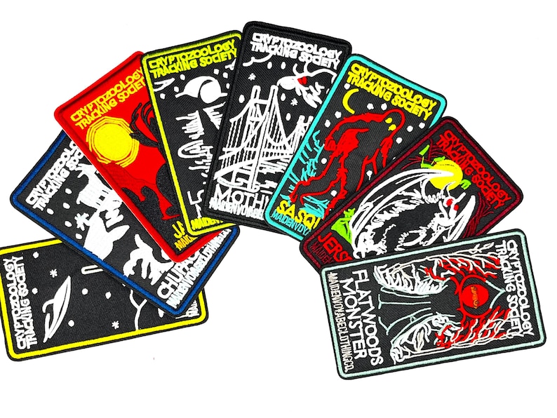 May include: A set of nine embroidered patches featuring various cryptids, including the Mothman, Jersey Devil, Sasquatch, Flatwoods Monster, and Chupacabra. Each patch features a black background with white and yellow outlines, and the text "Cryptozoology Tracking Society" is printed on each patch.