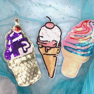 May include: Three sequined ice cream cone patches. One is purple and white, one is pink and blue, and one is white and pink.
