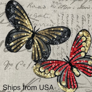 May include: Two embroidered butterfly patches with sequins. One butterfly is black and gold, the other is red and gold.