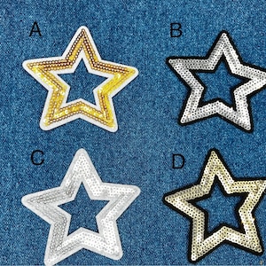 May include: Four star-shaped sequin patches in gold and silver tones, each with a different design. The patches are set against a blue denim background. The patches are labeled A, B, C, and D.