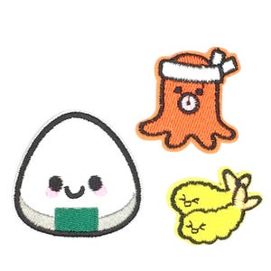 May include: Three embroidered iron-on patches featuring a smiling onigiri rice ball, a smiling octopus wearing a headband, and two smiling tempura shrimp.