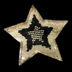 May include: A gold star-shaped sequin patch with a black star in the center. The patch is perfect for adding a touch of sparkle to clothing, bags, or other crafts.