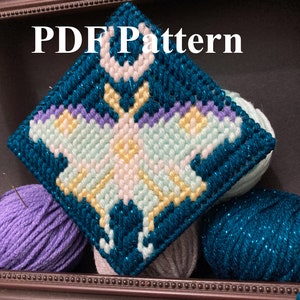 May include: A close-up of a completed butterfly-shaped cross-stitch project. The butterfly is made with light blue, yellow, white, and purple yarn. The project is framed in a brown wooden frame. The text "PDF Pattern" is visible at the top of the image.