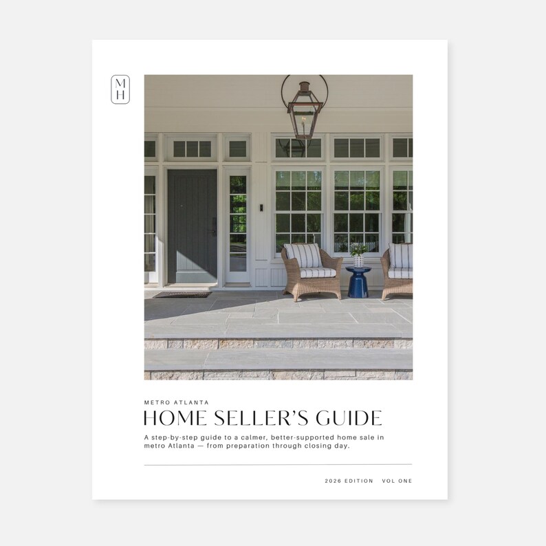May include: A white document cover titled Metro Atlanta Home Seller's Guide 2026 Edition Vol One. The cover features a photograph of a house exterior with a dark gray door, white window frames, two wicker chairs, and a blue side table on a stone porch.
