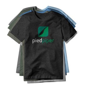 May include: A stack of short-sleeved t-shirts in various colors, including charcoal gray, green, and blue. The front shirt is charcoal gray with the text "piedpiper" below a green and blue leaf logo.