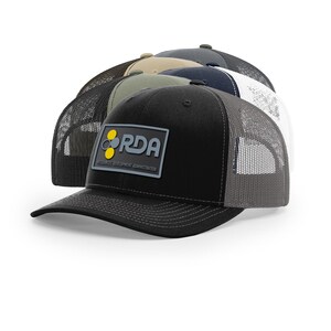 May include: A stack of trucker hats in various colors, including black, gray, and navy. Each hat features a mesh back and a front patch with the text "RDA RESOURCES DEVELOPMENT ADMINISTRATION".