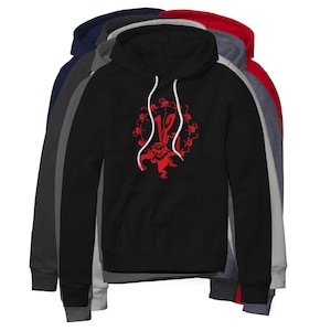 May include: A black hooded sweatshirt featuring a red graphic print of the number 12 surrounded by a circular arrangement of small monkey silhouettes. The hoodie includes a front kangaroo pocket and white drawstring cords at the neckline.