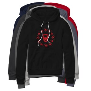 May include: A black hooded sweatshirt featuring a central red graphic of a gorilla face surrounded by a circular pattern of smaller monkey silhouettes. The hoodie includes a front kangaroo pocket and white drawstrings at the neckline.