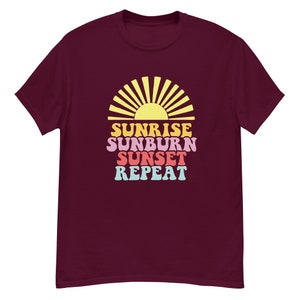Peut inclure: Un t-shirt marron avec un graphique de soleil jaune et le texte "Sunrise Sunburn Sunset Repeat" dans un schéma de couleurs arc-en-ciel.