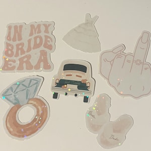 May include: A set of seven glittery stickers with a wedding theme. The stickers include a car with "Just Married" on the back, a ring with a diamond, a hand giving the middle finger with a ring on it, a dress, two chickens with "Bride" written on them, and a sticker that says "In My Bride Era".