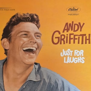 May include: Vintage vinyl record album cover featuring Andy Griffith with the title "Just For Laughs." The cover is predominantly orange with Griffith's smiling face and the Capitol Records logo. The album title and artist name are in a bold, retro font.