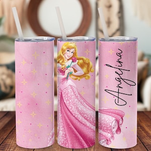 以下が含まれることがあります： ピンクとゴールドのパーソナライズされたタンブラーで、ピンクのドレスを着たバラを持ったプリンセスのグラフィックが描かれています。タンブラーには「アンジェリーナ」という名前が書かれています。