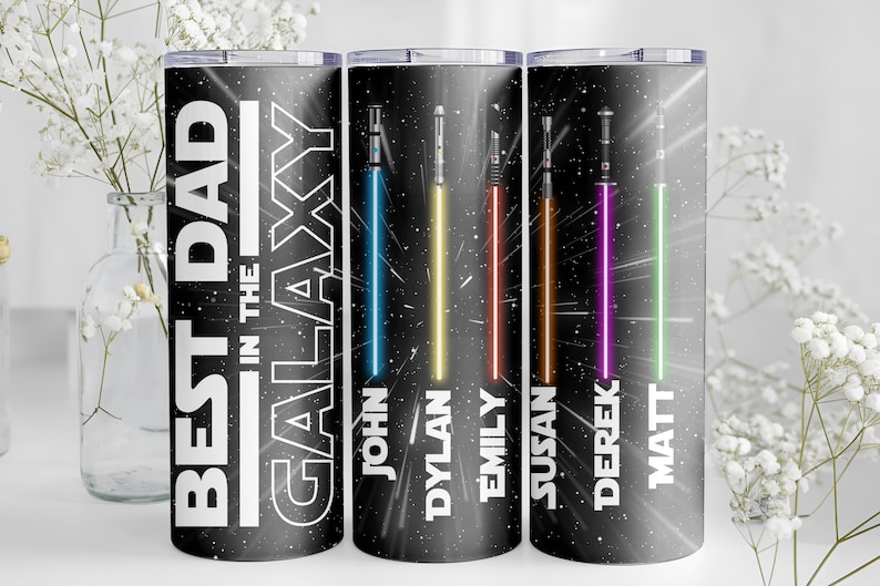 K&ouml;nnte beinhalten: Ein schwarzer Becher mit dem Text "BEST DAD in the GALAXY" in Wei&szlig;. Der Becher zeigt farbenfrohe Lichtschwert-Designs mit den Namen: John, Dylan, Emily, Susan, Derek und Matt. Das Design ist vor einem Sternenhintergrund.