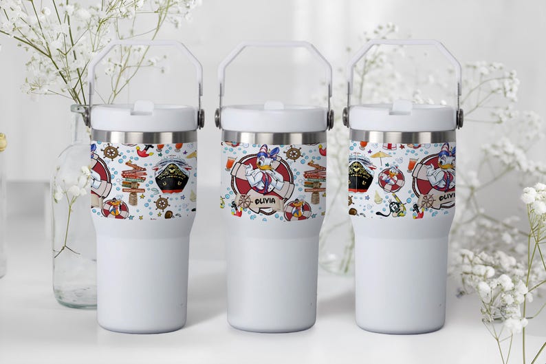May include: Three white insulated tumblers with a nautical-themed design featuring cartoon characters, ships, and nautical elements. The design includes the name "Olivia" on one of the tumblers. Each tumbler has a white handle.