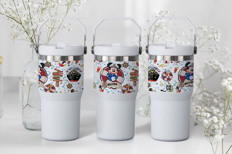 May include: Three white insulated tumblers with a handle. Each tumbler features a nautical-themed design with Mickey Mouse, a cruise ship, and other nautical elements. The name "Oliver" is printed on one of the tumblers.
