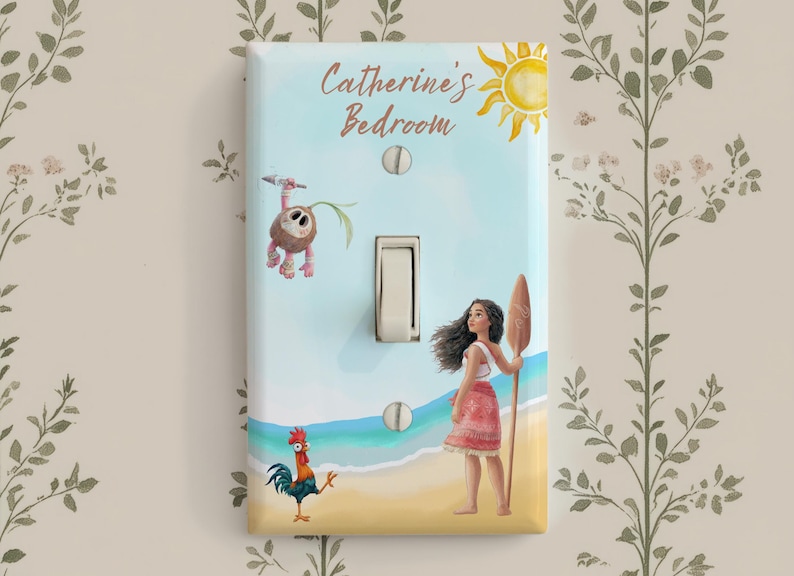 May include: A rectangular light switch cover featuring a beach scene with a cartoon girl holding a wooden oar, a small rooster, and a coconut creature. The text Catherine's Bedroom is printed at the top with a yellow sun illustration.