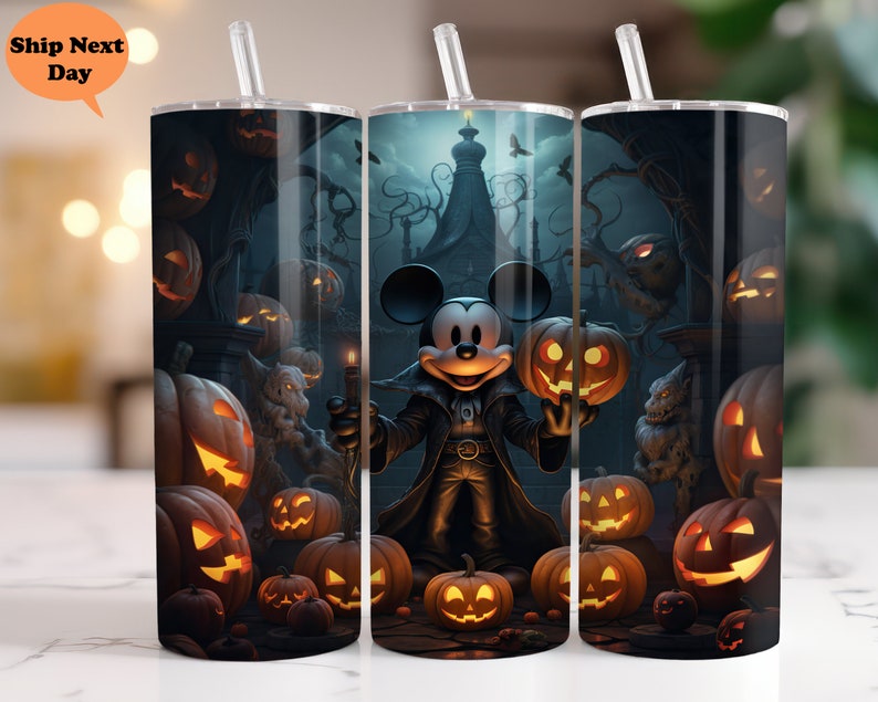 May include: A set of three stainless steel tumblers with a Halloween theme. The tumblers feature a black and white illustration of Mickey Mouse dressed as a vampire, surrounded by pumpkins and other Halloween imagery.