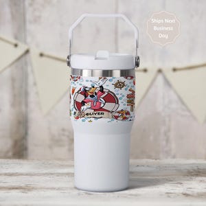 May include: A white ceramic mug with a black handle and the text "But First, Coffee" in a black, bold font. The mug is on a white surface.