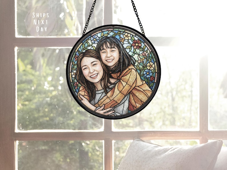 May include: A round, stained glass window art piece featuring a portrait of two smiling people embracing. The artwork is surrounded by a floral design in various colors and is framed in black. The text "SHIPS NEXT DAY" is visible.