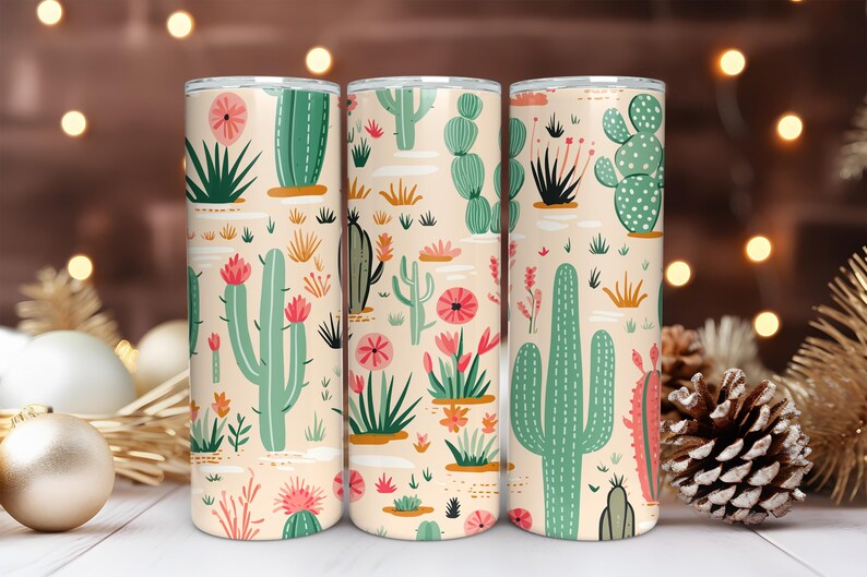 May include: Three cylindrical tumblers featuring a repeating pattern of various green cacti and pink flowers on a light beige background. The design includes tall saguaro-style cacti, round prickly pear cacti, and small desert succulents.