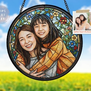 May include: Round stained glass art piece featuring a portrait of two smiling people, surrounded by a floral design. The artwork is framed in black and hangs from a chain. The text "Send Your Picture" is visible.