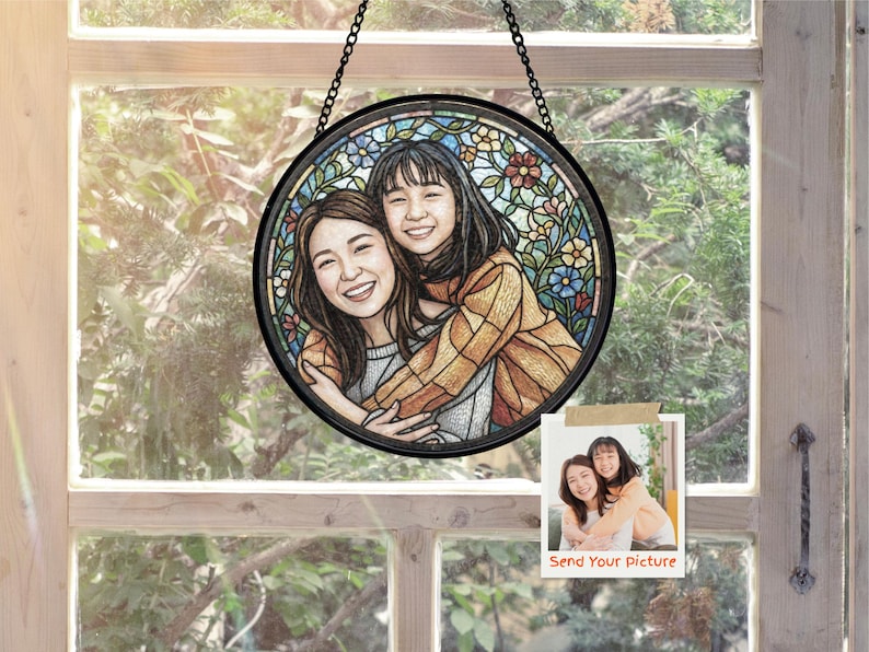 May include: A round stained glass window with a black frame, depicting two smiling women embracing. The background features colorful floral patterns. A small photo with the text "Send Your Picture" is attached.