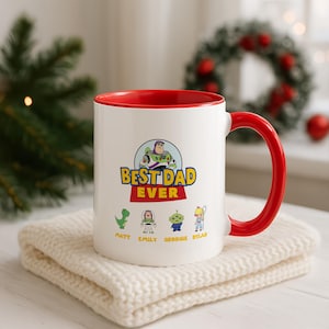 May include: A white ceramic mug with a bright red interior and handle. The front features a graphic of Buzz Lightyear above the text BEST DAD EVER, with smaller illustrations of Rex, Buzz, an alien, and Bo Peep, labeled Matt, Emily, Georgie, and Dylan.